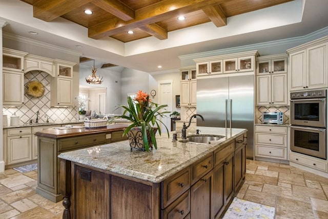 kitchen featuring stainless steel appliances, sink, and cream cabinetry