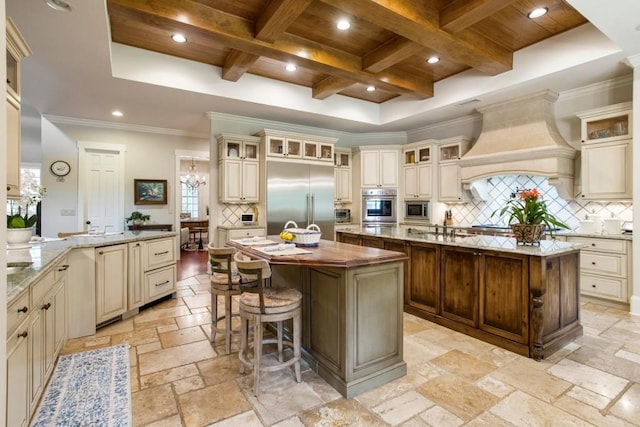 kitchen with an island with sink and cream cabinets