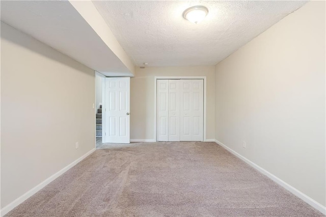 4412 Rustic Wood Dr, Stone Mountain, GA 30083 - unfurnished bedroom featuring a textured ceiling, light colored carpet, and a closet
