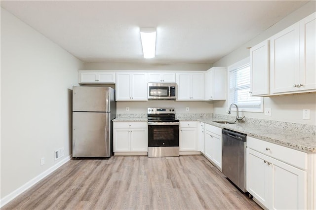 4412 Rustic Wood Dr, Stone Mountain, GA 30083 - kitchen featuring white cabinets, sink, light wood-type flooring, appliances with stainless steel finishes, and light stone counters