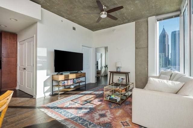 living room featuring visible vents, a ceiling fan, and wood finished floors