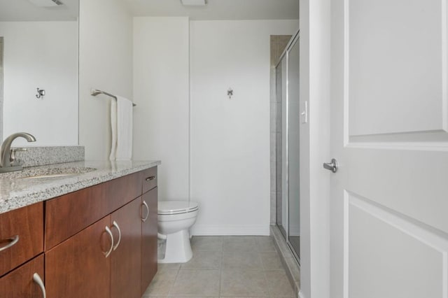 bathroom featuring toilet, a stall shower, vanity, and tile patterned flooring