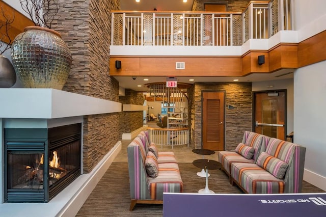 living area featuring visible vents, a multi sided fireplace, and a high ceiling