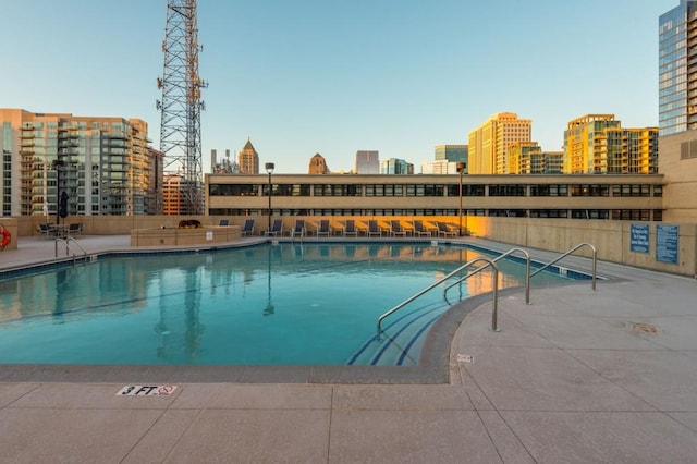 view of pool with a view of city and a patio area