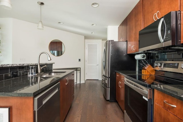 kitchen featuring dark stone countertops, dark wood-style floors, a sink, stainless steel appliances, and tasteful backsplash