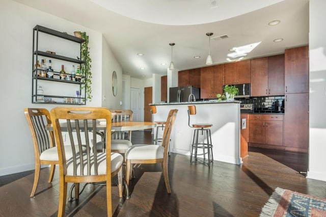 dining room with recessed lighting, dark wood-style floors, visible vents, and baseboards