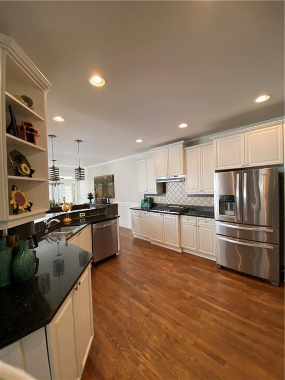 kitchen with white cabinetry, dark hardwood / wood-style floors, pendant lighting, stainless steel appliances, and decorative backsplash