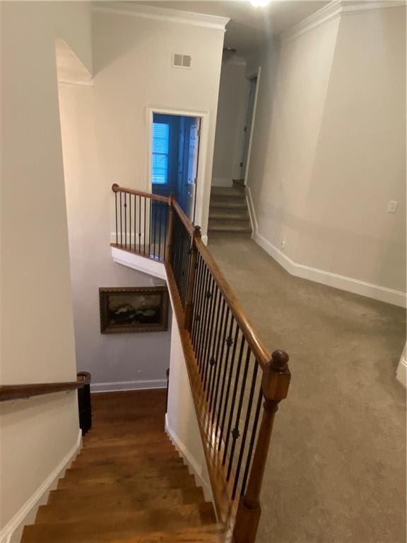 stairs featuring crown molding and wood-type flooring