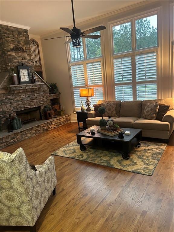 living room with ceiling fan, ornamental molding, a fireplace, and hardwood / wood-style floors