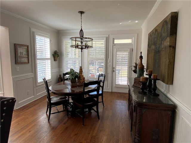 dining room with a notable chandelier, dark wood-type flooring, and ornamental molding