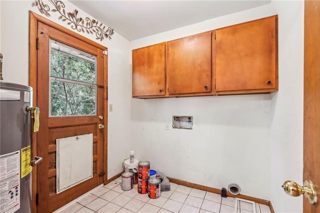 laundry area featuring cabinet space, water heater, light tile patterned floors, washer hookup, and baseboards