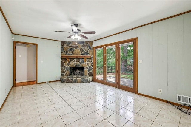 unfurnished living room with baseboards, ceiling fan, visible vents, crown molding, and a fireplace