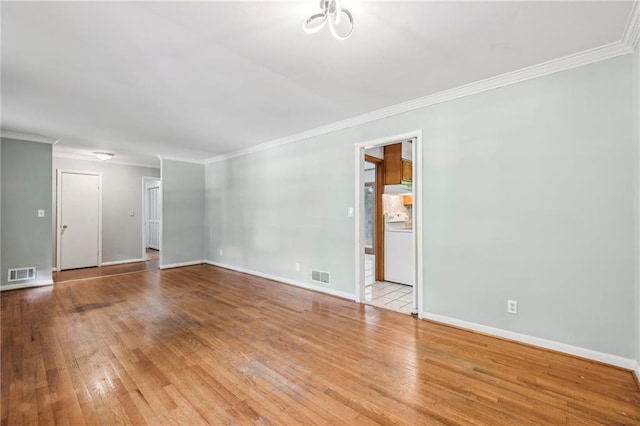 spare room featuring visible vents, wood finished floors, baseboards, and ornamental molding