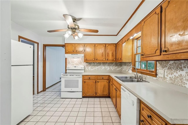 kitchen featuring brown cabinetry, white appliances, a sink, decorative backsplash, and light countertops