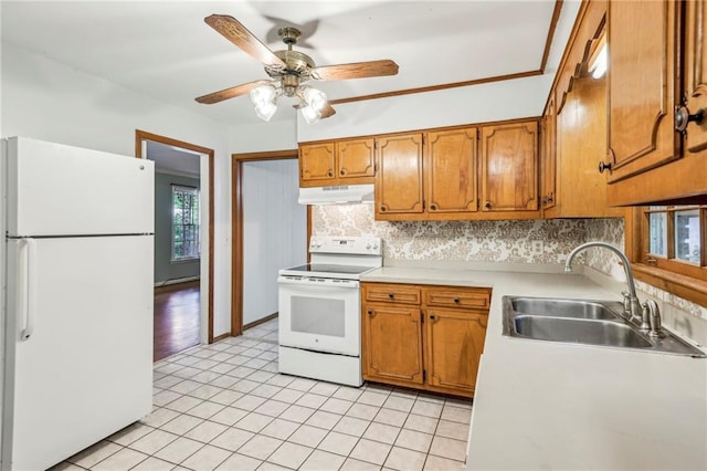 kitchen with under cabinet range hood, brown cabinetry, white appliances, a sink, and tasteful backsplash