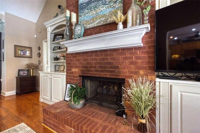 living room featuring a fireplace, lofted ceiling, and hardwood / wood-style floors