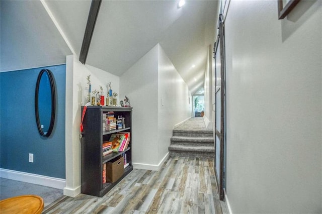 hallway featuring vaulted ceiling and hardwood / wood-style floors