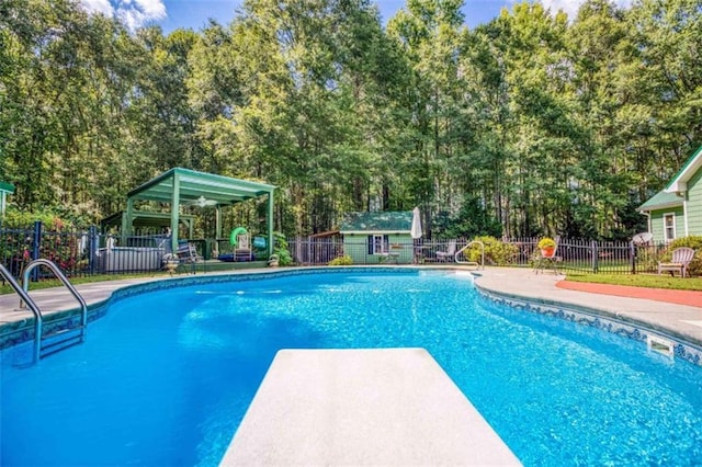 view of swimming pool with a diving board and a patio