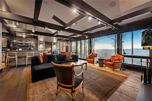 sunroom featuring a chandelier, beam ceiling, and track lighting