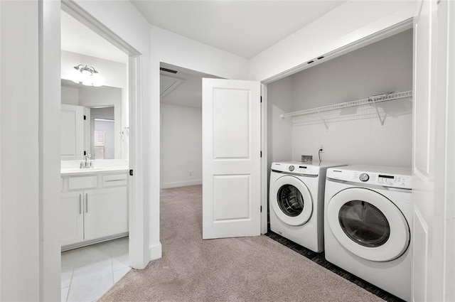 clothes washing area featuring light colored carpet, a sink, washer and dryer, laundry area, and baseboards