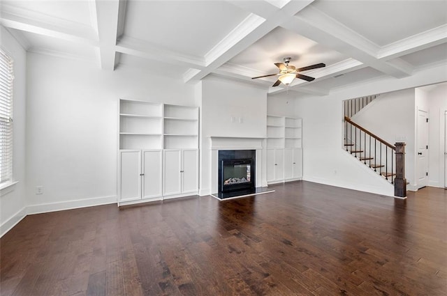 unfurnished living room featuring a glass covered fireplace, stairway, dark wood finished floors, and baseboards