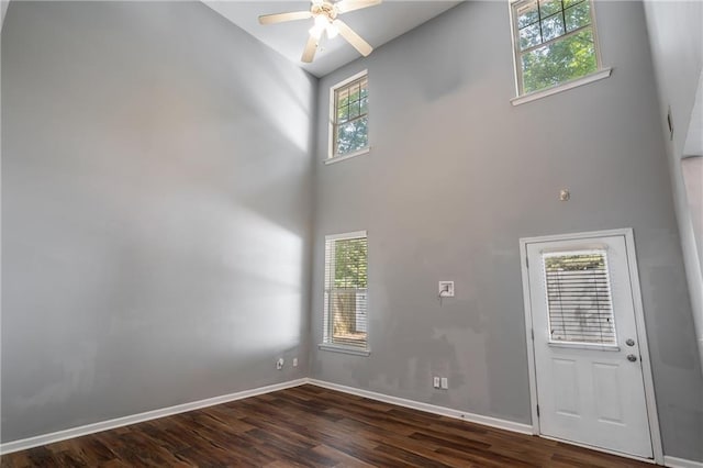 208 Oconee Way, Canton, GA 30114 - spare room featuring a towering ceiling, dark wood-style flooring, ceiling fan, and baseboards