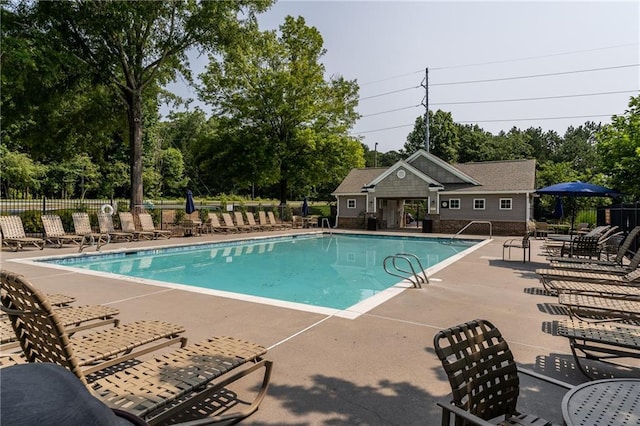208 Oconee Way, Canton, GA 30114 - community pool with a patio, view of wooded area, and an outbuilding