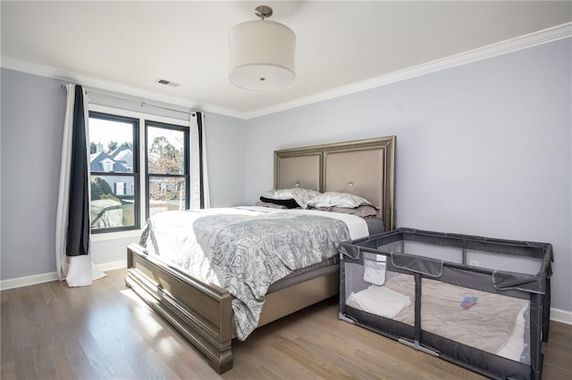 bedroom with hardwood / wood-style floors and ornamental molding