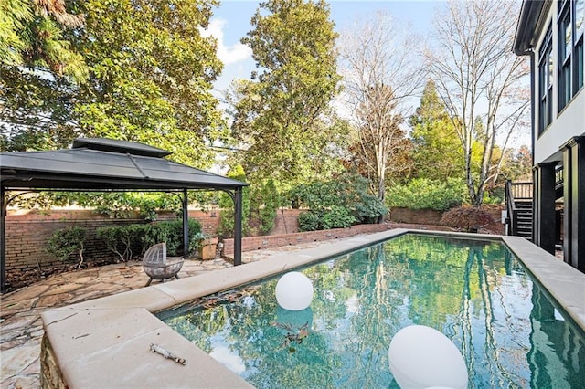 view of pool featuring a gazebo and an outdoor fire pit