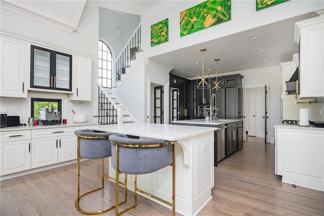 kitchen with tasteful backsplash, white cabinetry, and light hardwood / wood-style floors