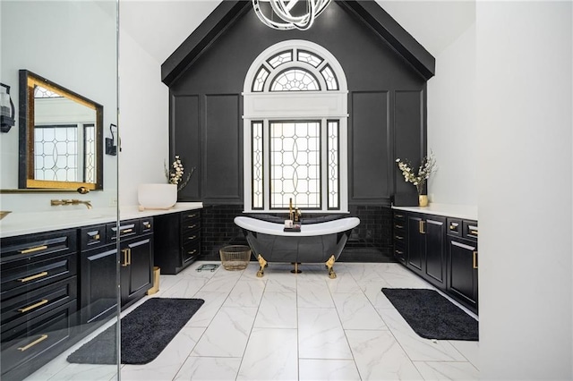 bathroom with a bath, vanity, and high vaulted ceiling