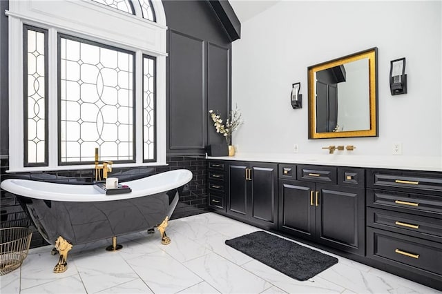 bathroom with a bathing tub, vanity, a wealth of natural light, and vaulted ceiling