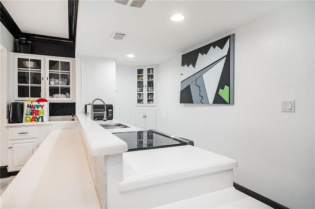 kitchen featuring white cabinets, black range, and sink