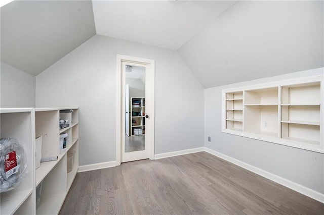 additional living space featuring hardwood / wood-style floors and lofted ceiling