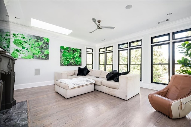 living room featuring ornamental molding, a healthy amount of sunlight, and wood-type flooring