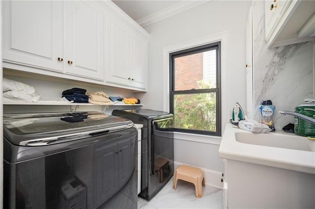 clothes washing area with cabinets, separate washer and dryer, ornamental molding, and sink