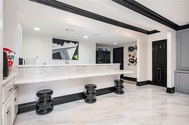 kitchen with black refrigerator with ice dispenser, kitchen peninsula, a breakfast bar area, white cabinets, and ornamental molding