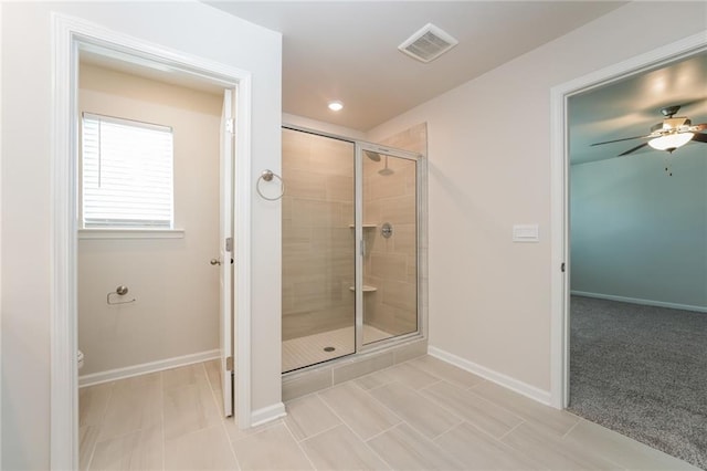 bathroom with a shower with shower door, tile patterned floors, toilet, and ceiling fan