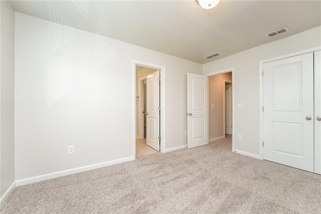 unfurnished bedroom featuring a closet and light carpet