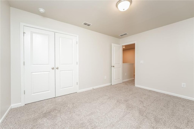 unfurnished bedroom with a closet and light carpet