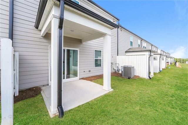 back of property with cooling unit, a patio, and a lawn