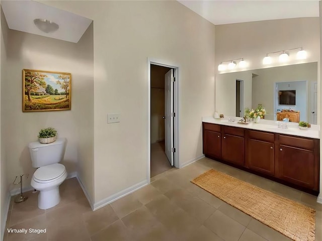 full bathroom with double vanity, toilet, high vaulted ceiling, baseboards, and tile patterned floors