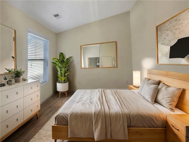 bedroom featuring lofted ceiling and dark hardwood / wood-style floors