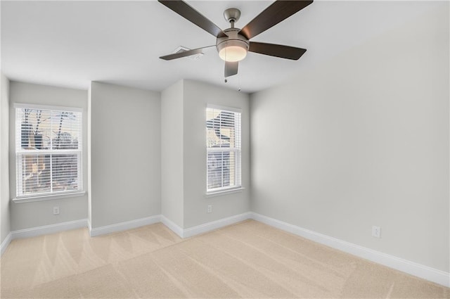 empty room featuring light carpet, a wealth of natural light, and ceiling fan