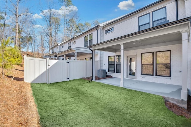 back of house with a patio area, central air condition unit, and a lawn