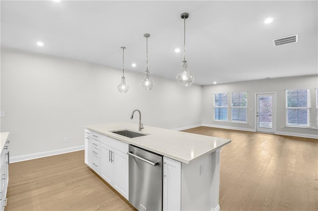 kitchen with sink, decorative light fixtures, stainless steel dishwasher, an island with sink, and white cabinets