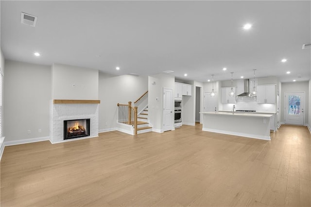 unfurnished living room with a fireplace and light hardwood / wood-style floors