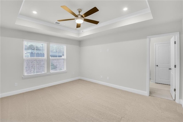 carpeted empty room with ceiling fan and a tray ceiling