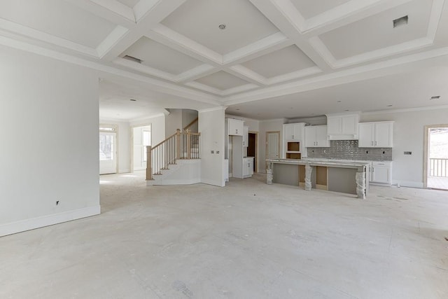 unfurnished living room with beamed ceiling and coffered ceiling