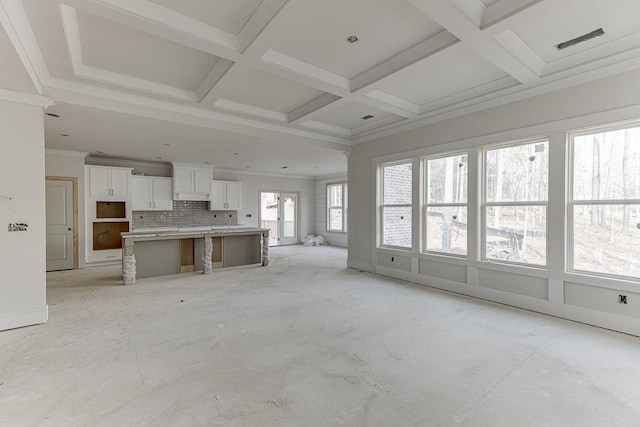 unfurnished living room with beam ceiling and coffered ceiling